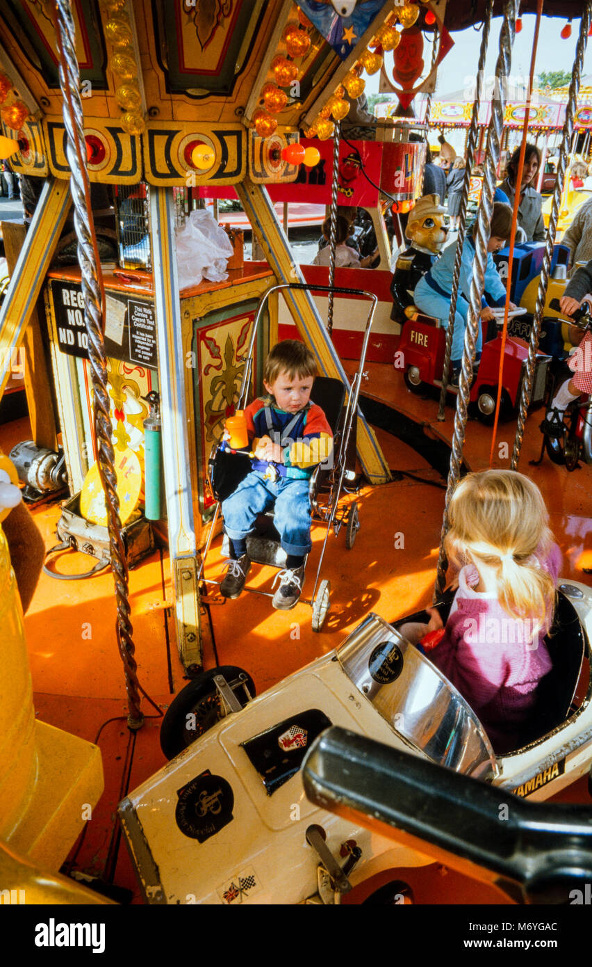 Junge Kinder auf einem kiddies Fahrt am Nottingham Goose Fair, eine jährliche Reisen Kirmes an der Walderholung in Nottingham, England statt, während der ersten Woche des Oktober. Archivierung Foto im Oktober 1987, England Stockfoto