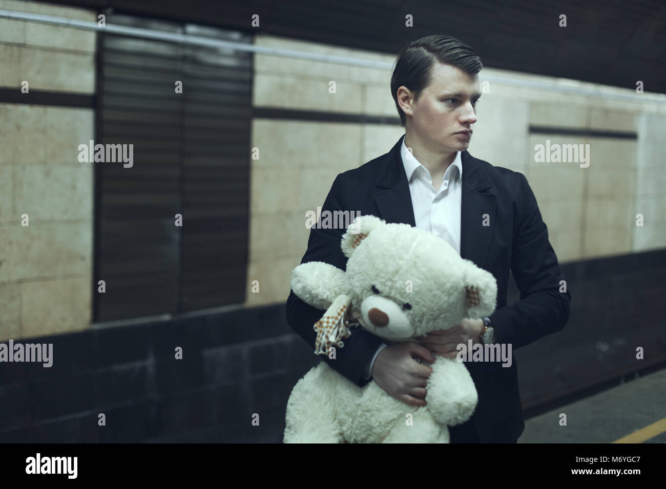 Junger Mann mit einem Teddybär, er sorgt sich vor der Sitzung. Stockfoto