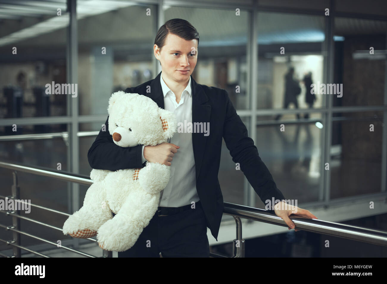 Junger Mann mit einem Teddybär in der Hand warten. Stockfoto