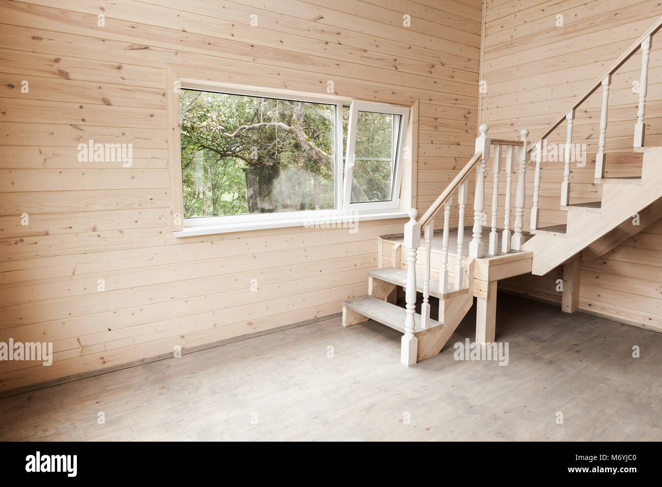 Leere neue Inneneinrichtung mit hölzernen Treppen und Fenster Stockfoto