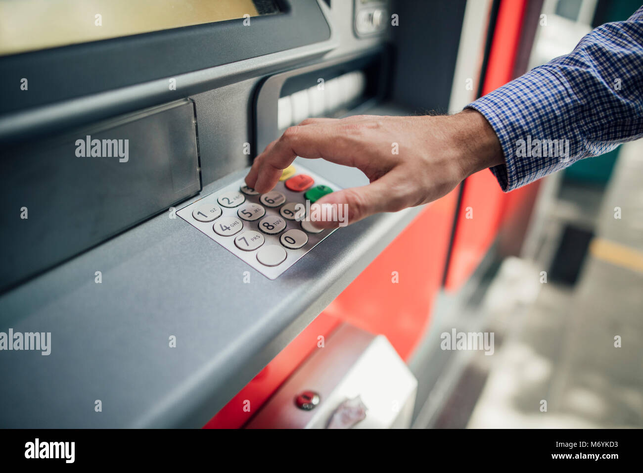 Nahaufnahme der Hand ein Geschäftsmann auf einem Geldautomaten Geld heraus zu erhalten. Stockfoto