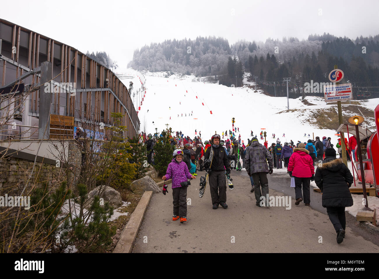 Eine Skipiste im Resort von Morzine in der Nähe des Stadtzentrums mit einer Menge von Menschen Haute Savoie Portes du Soleil Frankreich Stockfoto