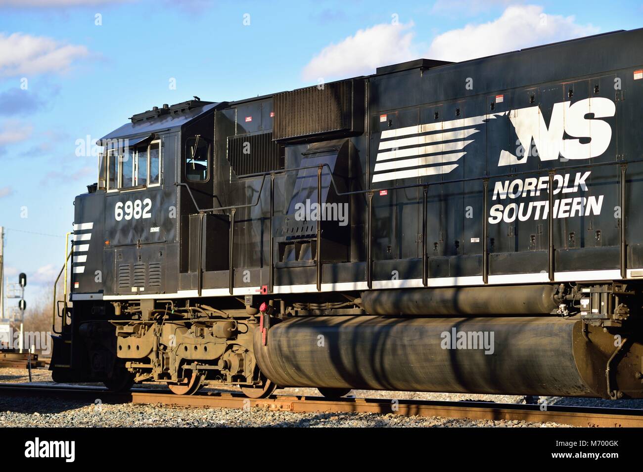 Elgin, Illinois, USA. Eine Lokomotive der Norfolk Southern Railway, die einen Zug durch einen Umsteigepunkt auf den Canadian National Railway Gleisen führt. Stockfoto