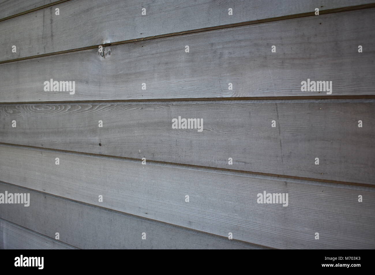 Aus nächster Nähe eine horizontal getäfelte Wand aus rotem Zedernholz mit natürlicher Körnung, Textur und verwitterten Grautönen Stockfoto