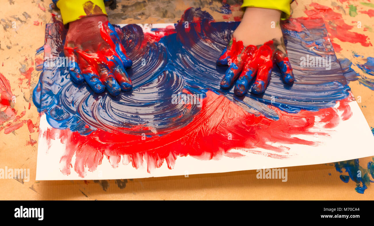 Kind Hände in bunten Farben gemalt. Bildung, Schule, Kreativität und Malerei Konzept. Soft Focus eine verschwommen Stockfoto