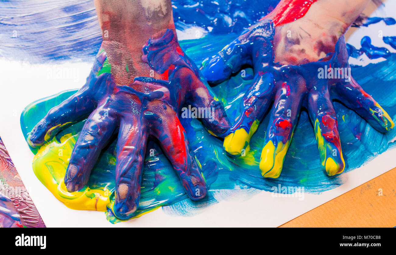 Kind Hände in bunten Farben gemalt. Bildung, Schule, Kreativität und Malerei Konzept. Soft Focus eine verschwommen Stockfoto