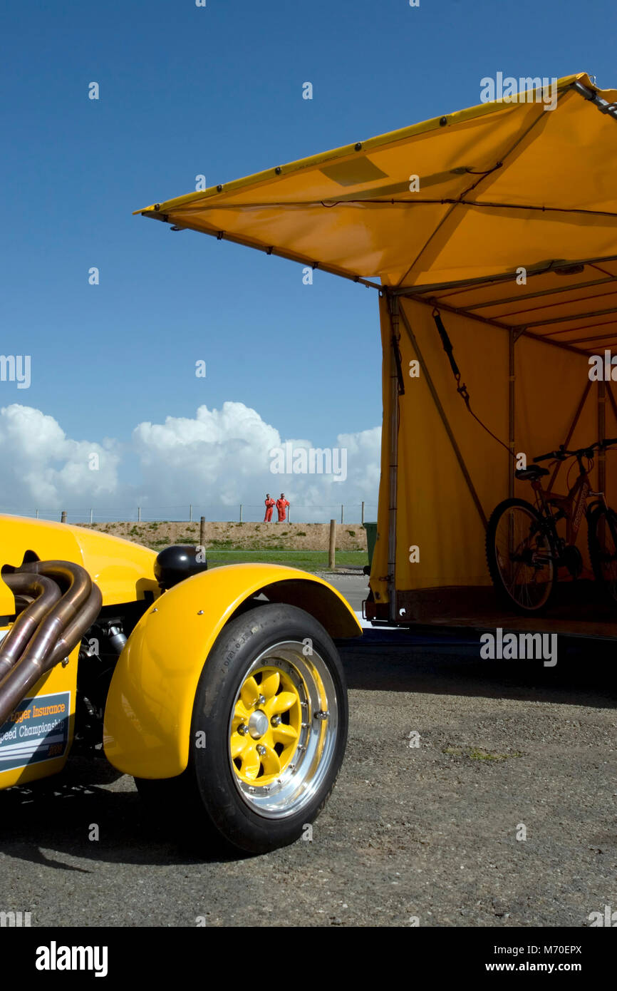 Gelber Sportwagen und offene Autotransporter, Anglesey, Wales Stockfoto