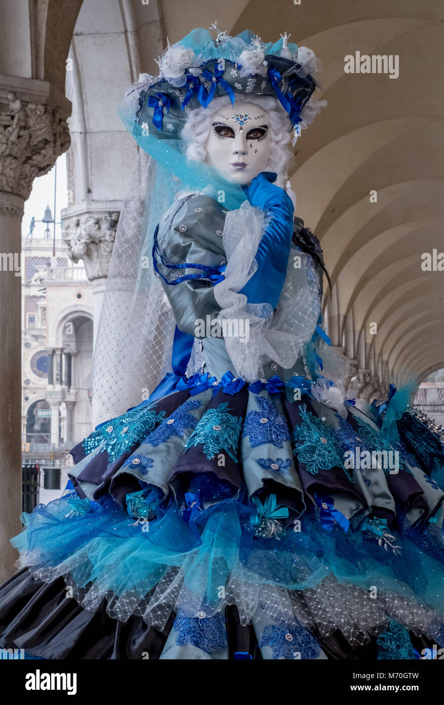 Frau in kunstvollen blauen und weißen Kostüm, Hut und Maske am Dogenpalast, Markusplatz (Palazzo Ducale San Marco) während des Karnevals Stockfoto