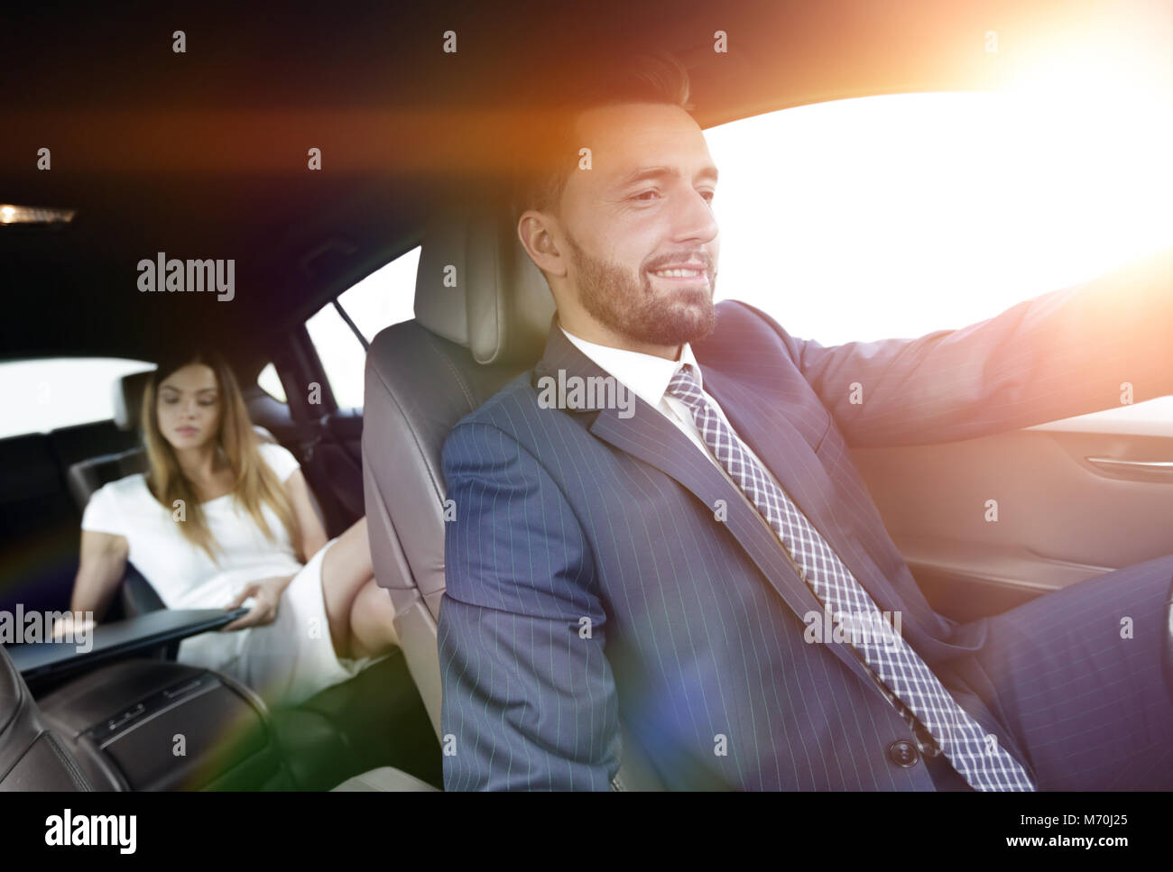 Unternehmer mit einem Computer im Auto gehen auf einer Geschäftsreise Stockfoto