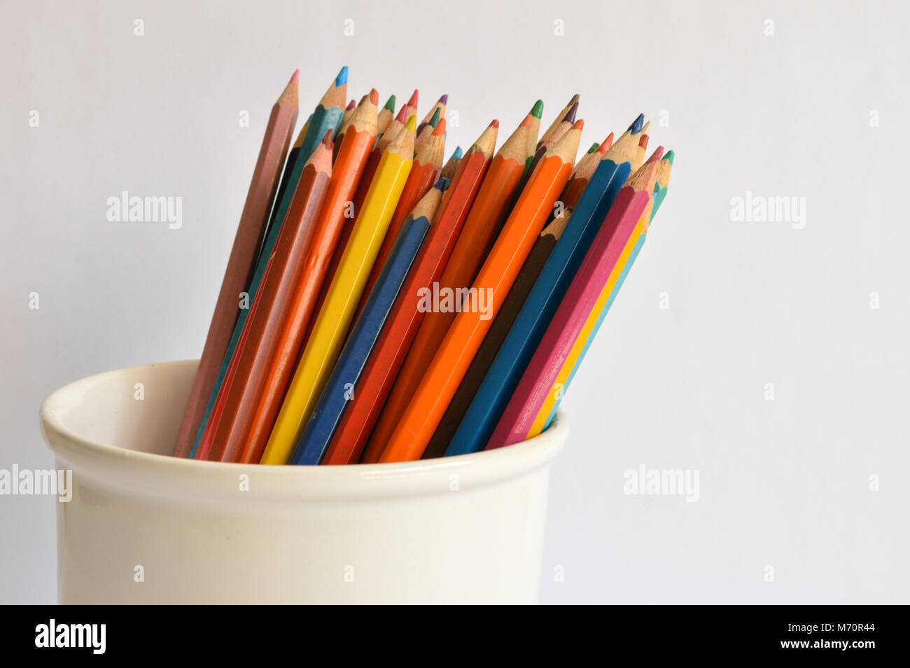 Buntstifte in einem Glas auf einem hellen Hintergrund Stockfoto