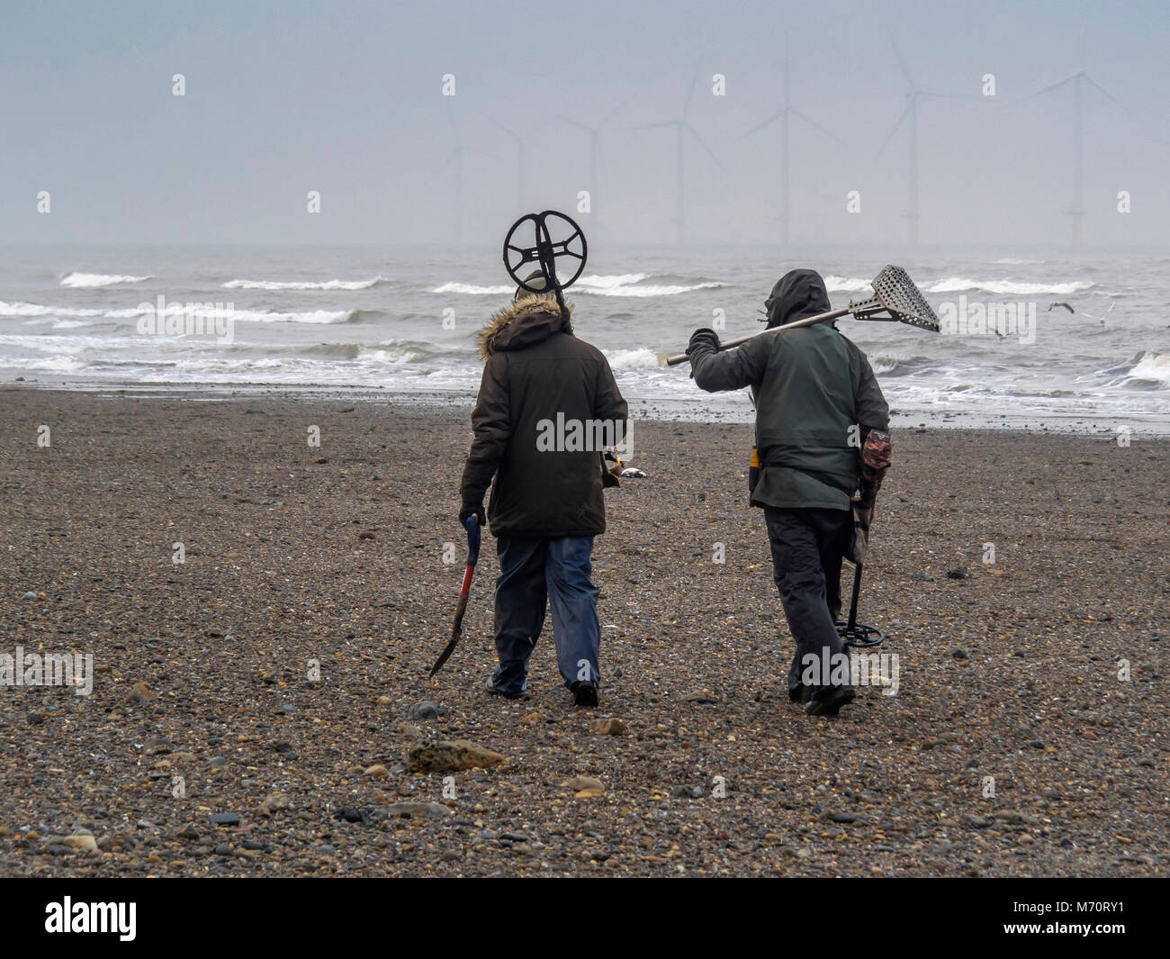 Zwei Männer mit Metalldetektor Ausrüstung entlang eine North Yorkshire  Strand nach einem Sturm auf einen neuen Standort suchen Stockfotografie -  Alamy
