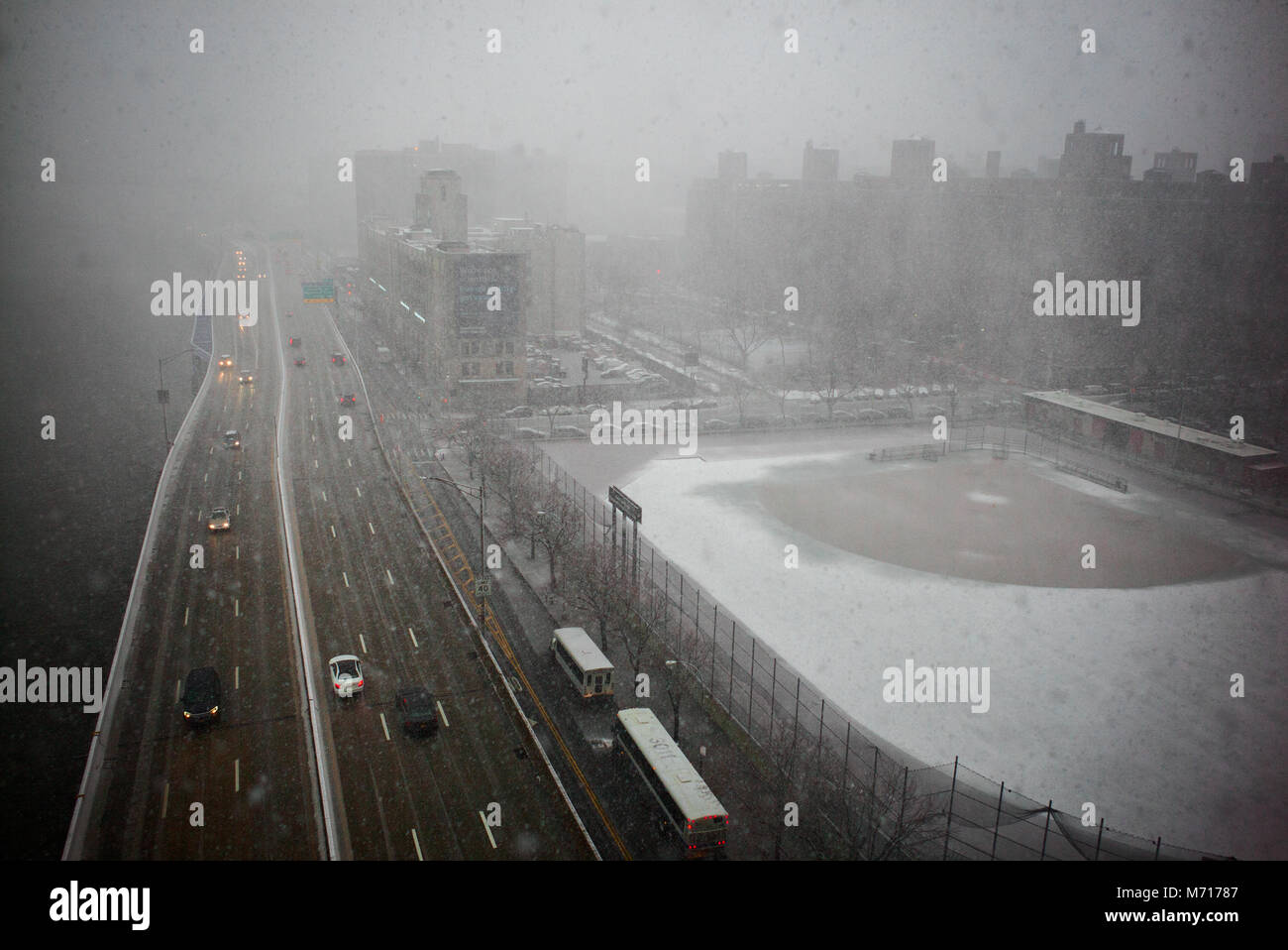 New York, NY, USA, 7. März, 2018. Verkehr auf New York City's FDR Drive übergibt einen Softball Feld mit Schnee bedeckt, wie die Stadt ihre zweite große Sturm in weniger als einer Woche Erfahrungen. Meteorologen waren die Vorhersage bis zu 10 Zoll (25 cm) Schnee durch die Zeit der Nor'easter endet. Stockfoto