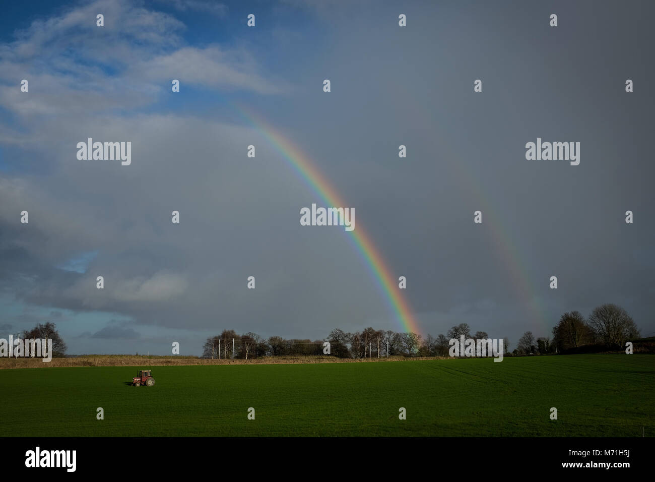 Doppelter Regenbogen über die grünen Felder des North Essex, England Stockfoto