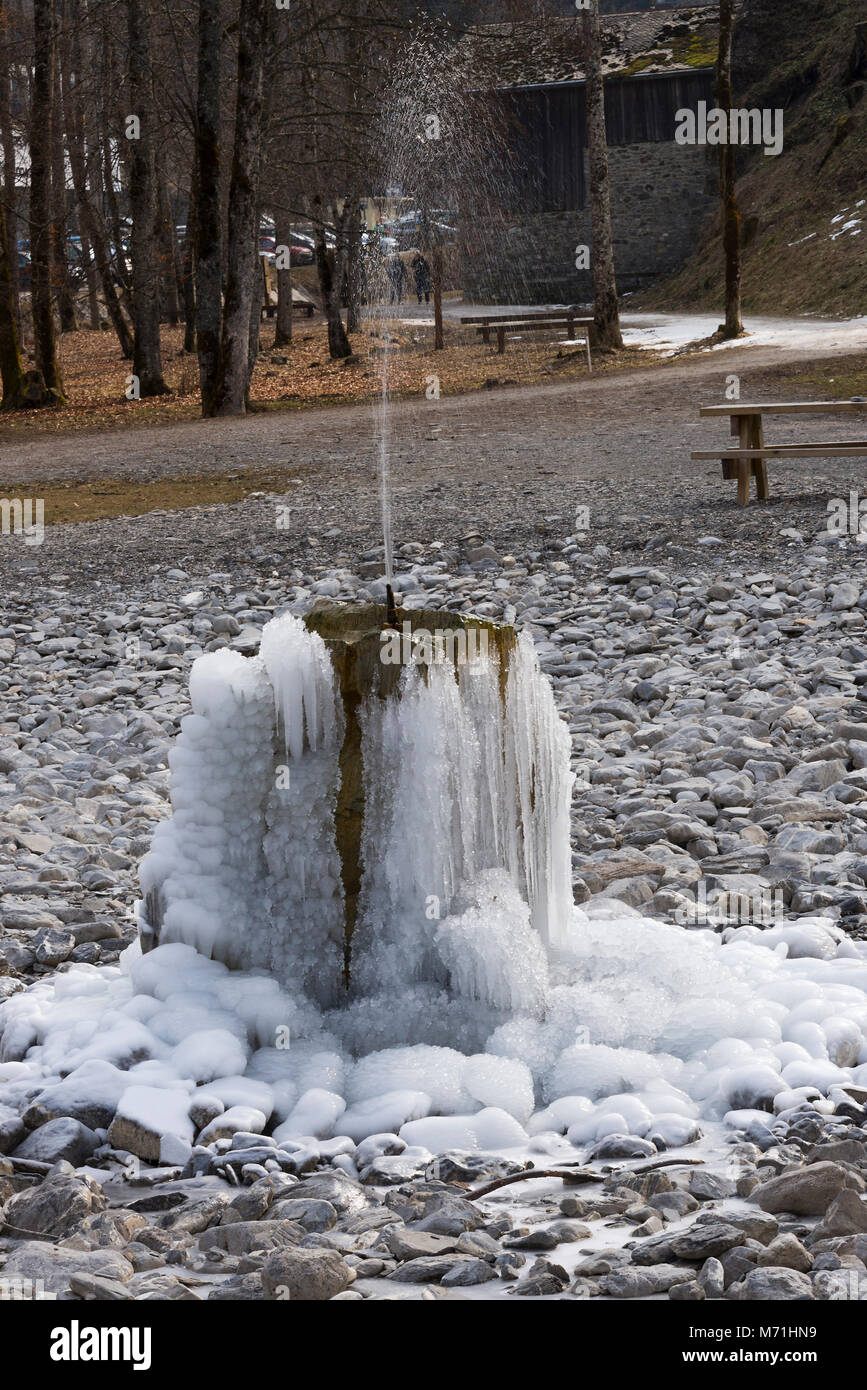 Eine gefrorene Brunnen abgedeckt, die im Eis in einem leeren Teich in Morzine Haute Savoie Portes du Soleil Frankreich Stockfoto