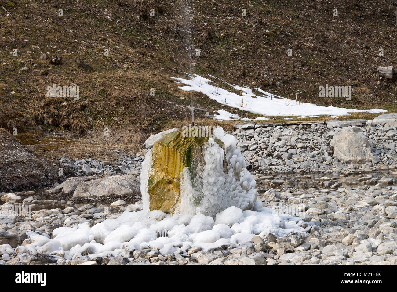 Eine gefrorene Brunnen abgedeckt, die im Eis in einem leeren Teich in Morzine Haute Savoie Portes du Soleil Frankreich Stockfoto