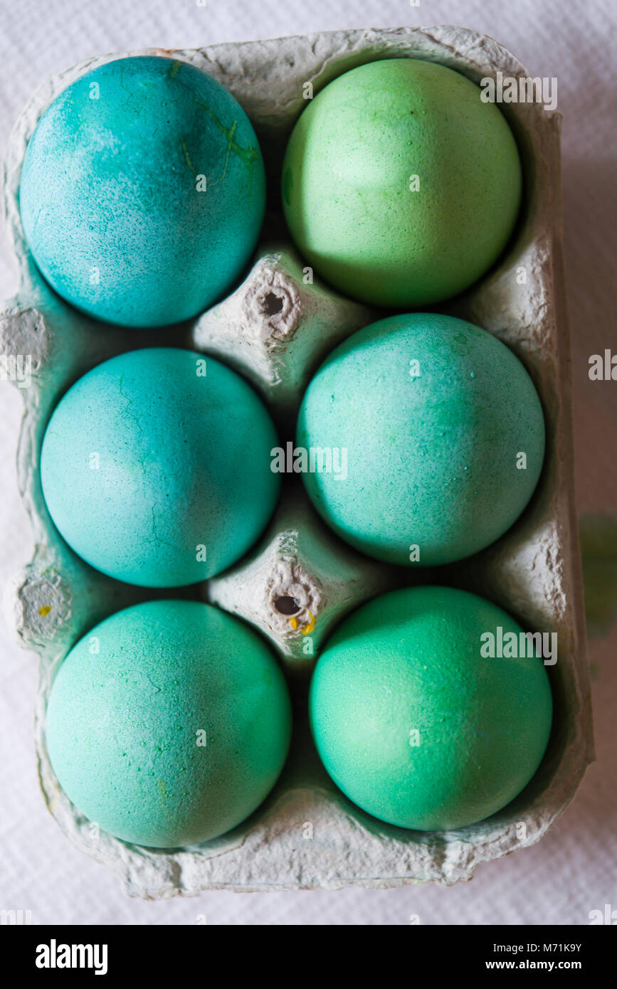 Pakete mit gefärbten Eiern zu Ostern, gefärbt mit Rot, Blau, Grün und rosa Farbstich im Paket sind über ein grauer Beton Hintergrund Stockfoto