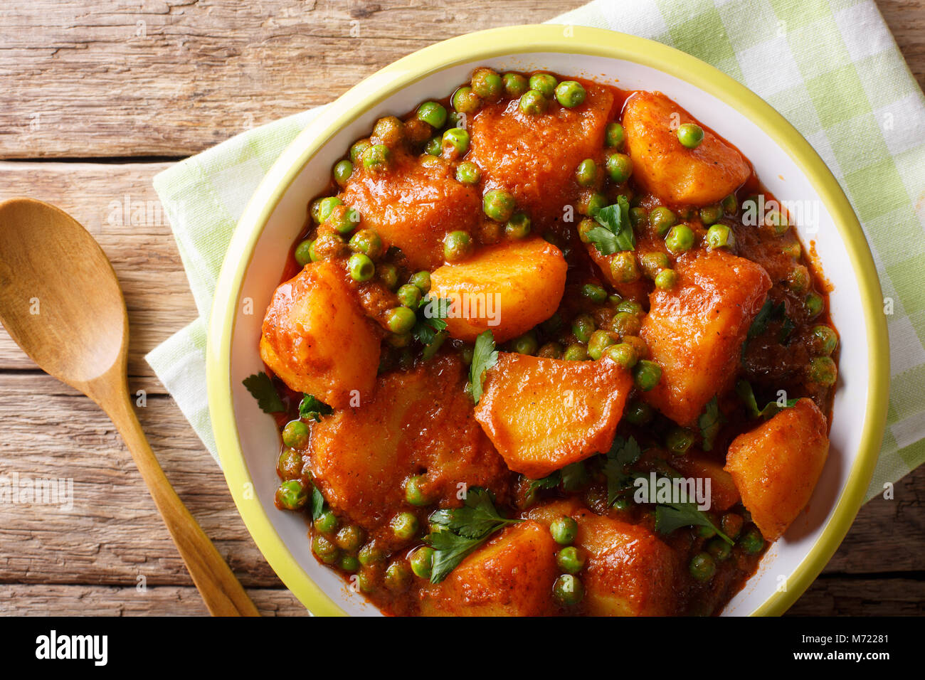 Home indisches Essen: aloo Matar - Kartoffeln, grüne Erbsen und pikanter Sauce closeup auf einem Teller. Horizontal oben Ansicht von oben Stockfoto