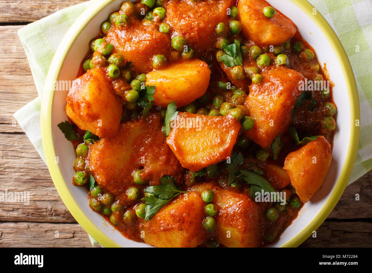 Würzige Aloo Matar Kartoffeln, grüne Erbsen und Gewürze close-up auf einem Teller. horizontal oben Ansicht von oben Stockfoto