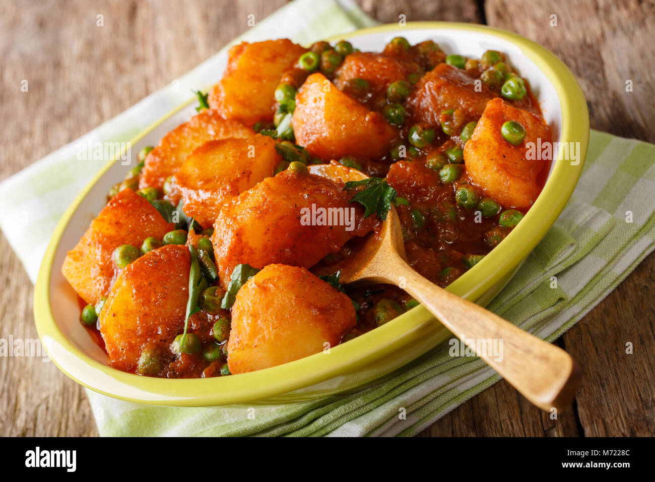 Home indisches Essen: aloo Matar - Kartoffeln, grüne Erbsen und pikanter Sauce closeup auf einem Teller. Horizontale Stockfoto