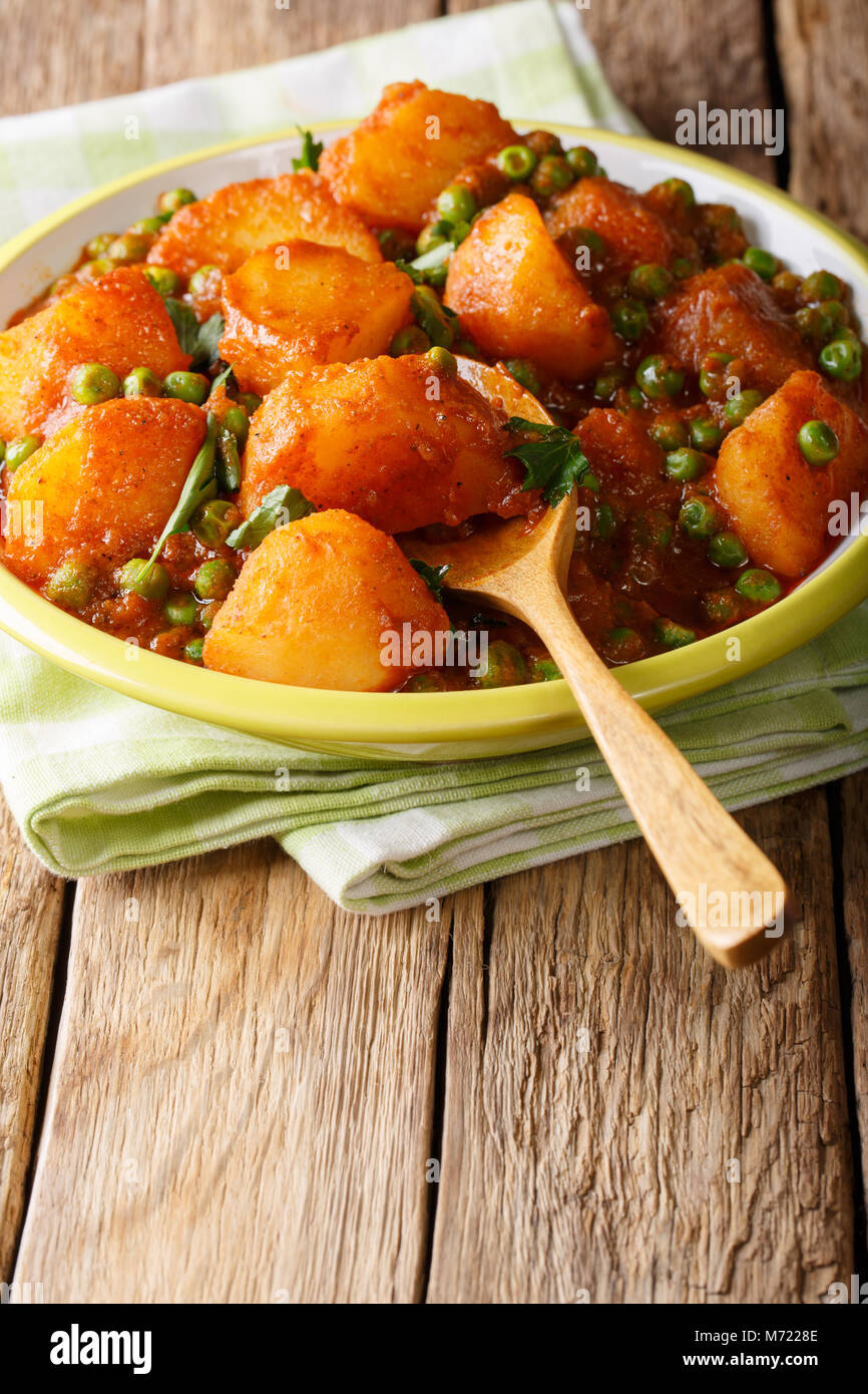 Würzigen indischen Aloo Matar Kartoffeln und Erbsen close-up auf einem Teller auf den Tisch. Vertikale Stockfoto