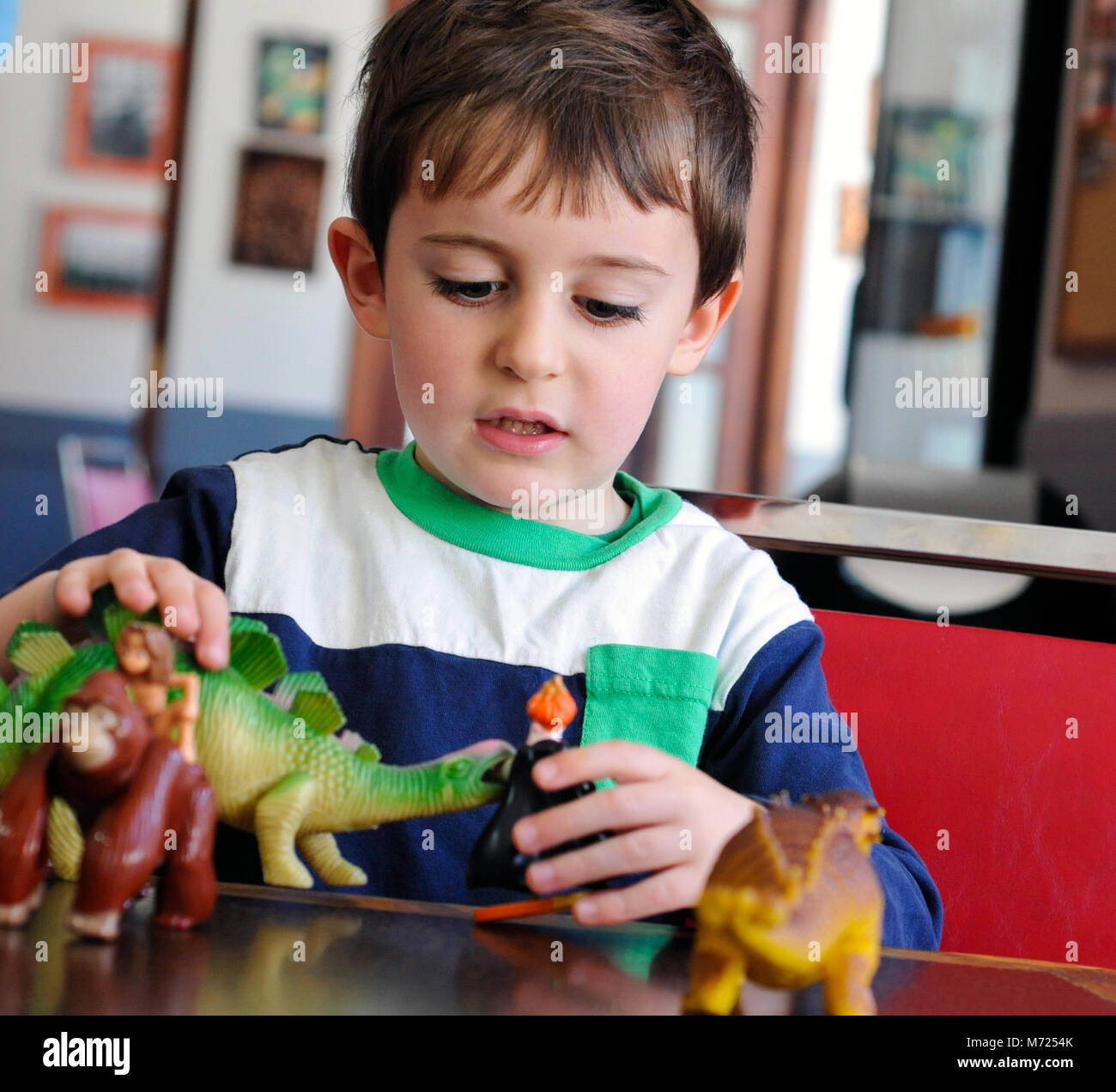 Kinder spielen mit Dinosaurier Stockfoto