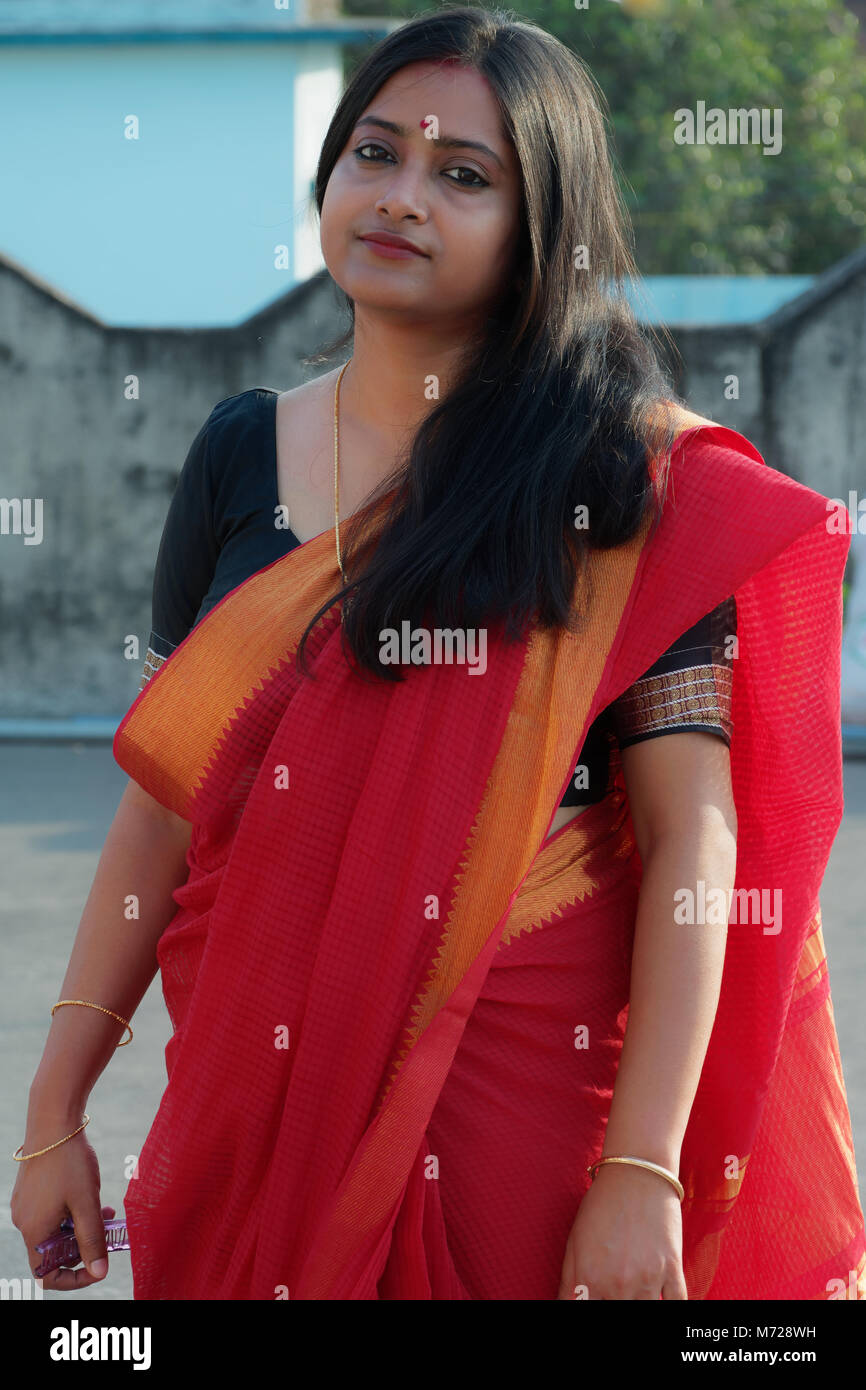 Schöne bengali Dame steht auf einer Dachterrasse einen roten Saree. Stockfoto