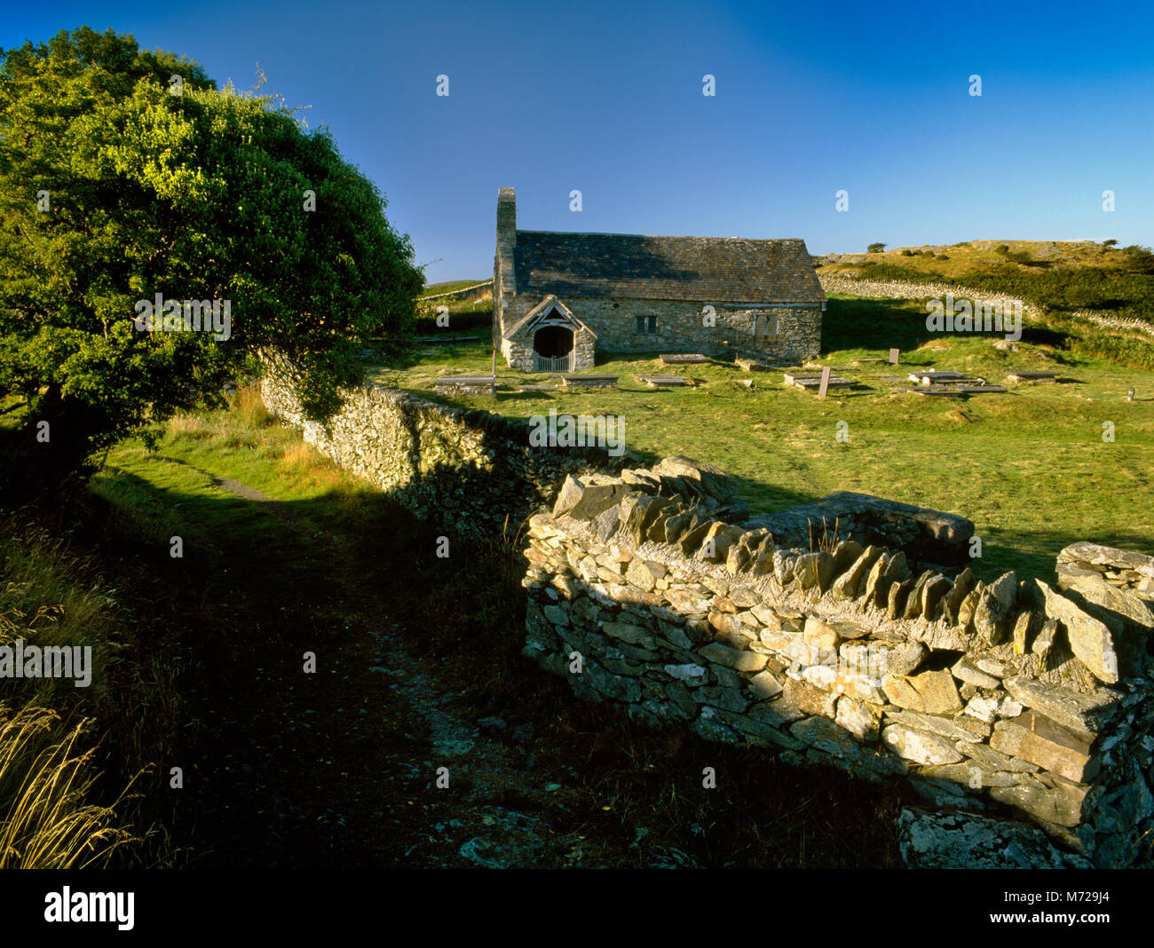 Anzeigen N St Celynin der Alten Kirche, Ffynnon Gelynin Llangelynin, mit heiligen Brunnen in S Ecke (in der Nähe von R) von Kirchhof: entfernte Lage oberhalb von Vale von Conwy Stockfoto