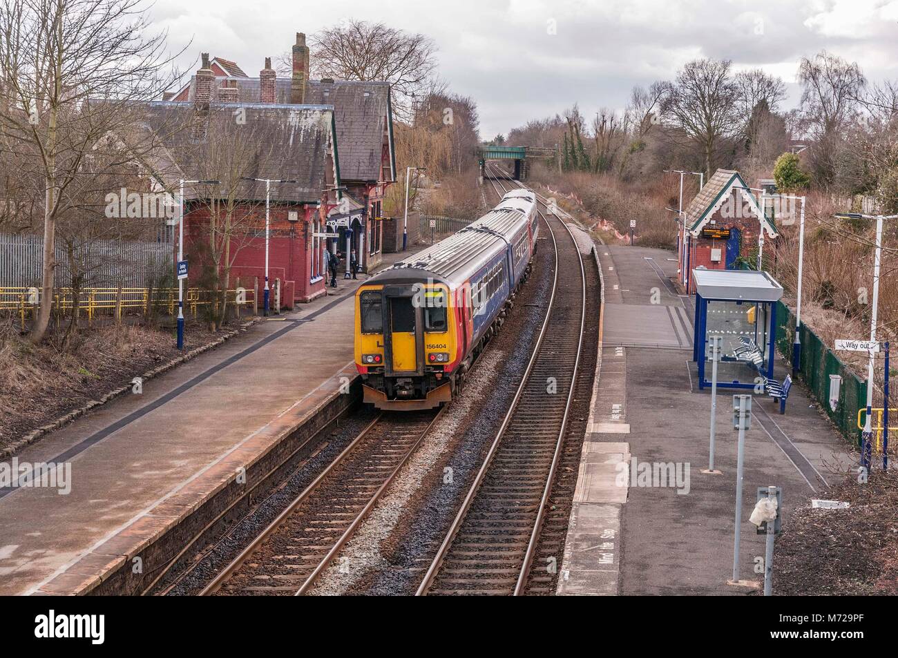 Eine Klasse 156 Diesel Multiple Unit Train durch die ländliche Station bei Sankey in Cheshire. East Midlands Trains Stockfoto