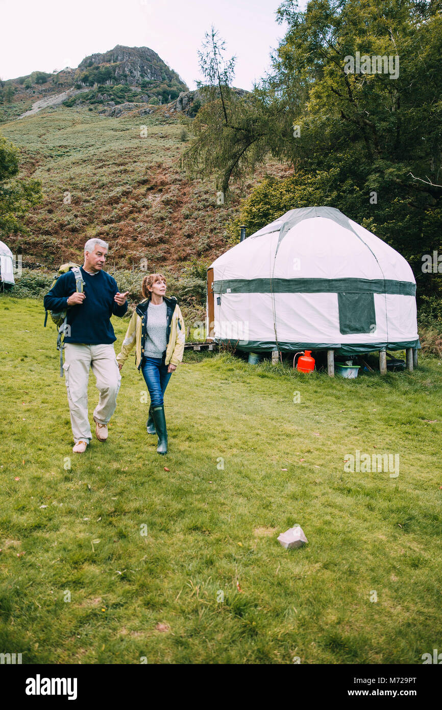 Senior Paar verlassen die Jurte sie Camping wurden für eine Wanderung rund um den See zu gehen. Stockfoto