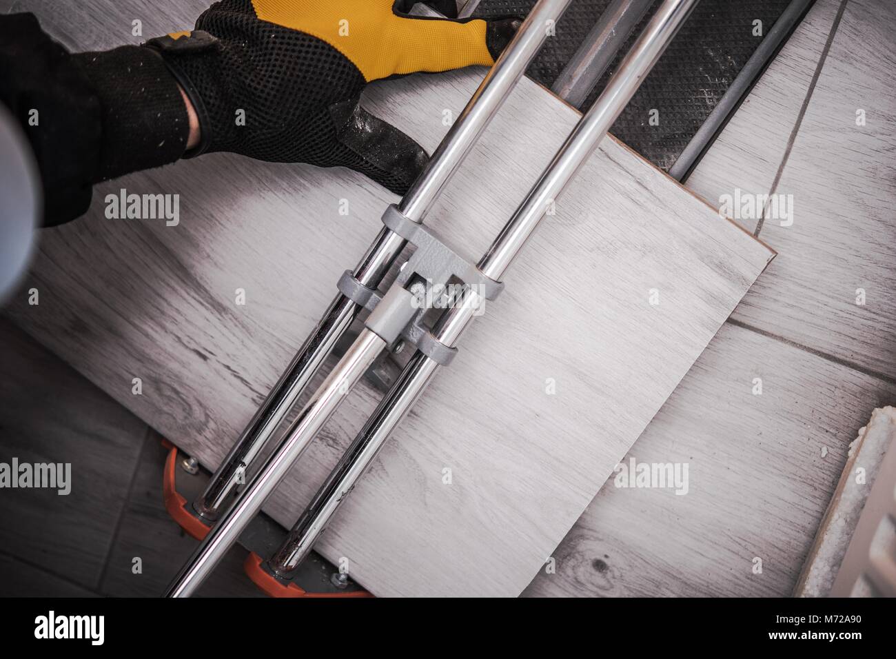 Badezimmer Fliesen Installation. Arbeiter schneiden von Fliesen mit Porzellan Tile Cutter. Innere Umbau Thema. Stockfoto