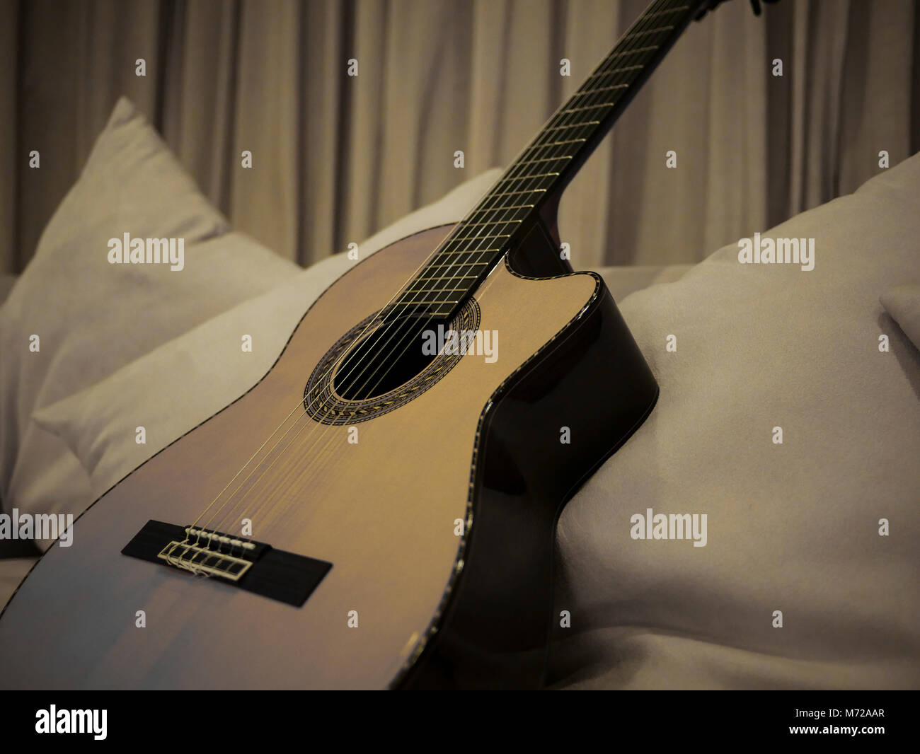 Ein monochromes Bild einer schönen Nylon String Guitar ruht auf einem weißen Tisch Stockfoto