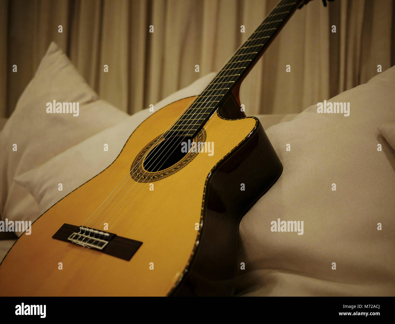 Ein Bild von einem schönen Nylon String Guitar ruht auf einem weißen Tisch Stockfoto