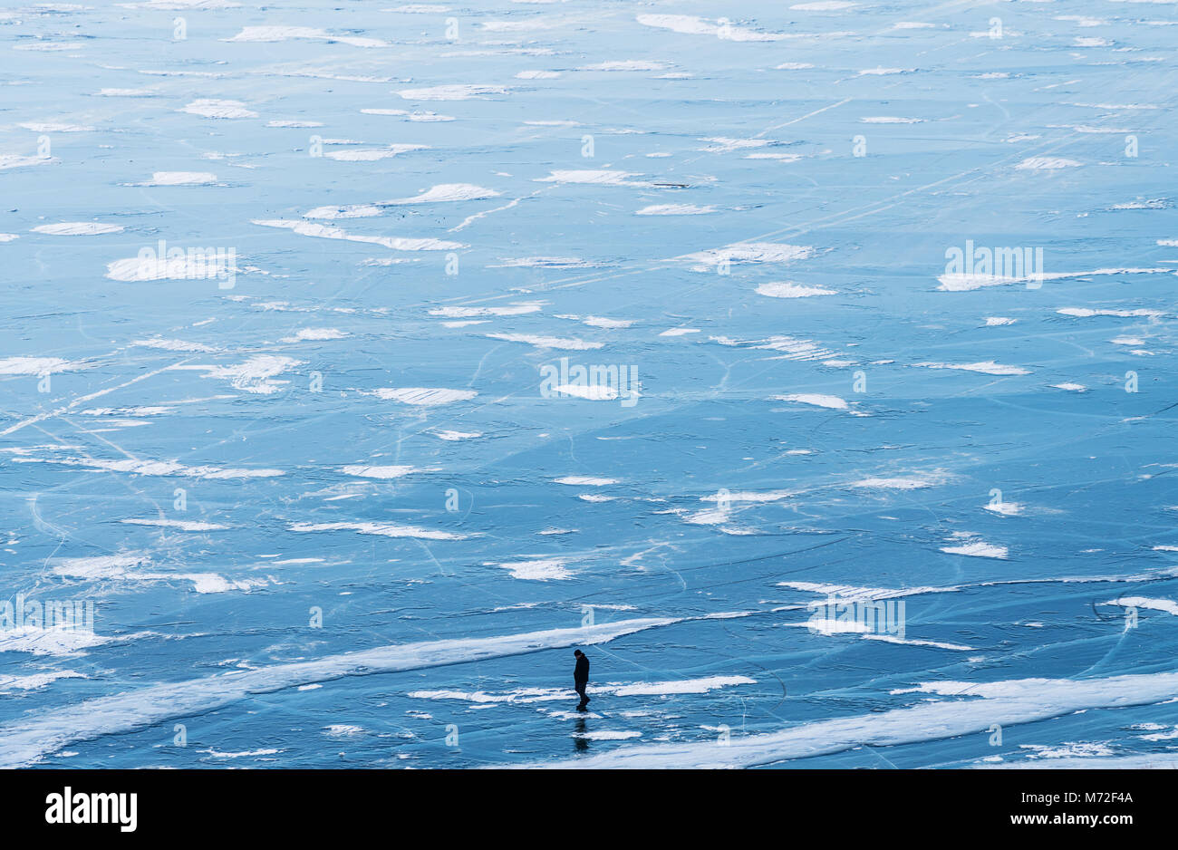 Gefrorenen Baikalsee Luftaufnahme Landschaft mit einem Mann auf dem Eis. Schöne gefrorenen See Landschaft Textur Stockfoto