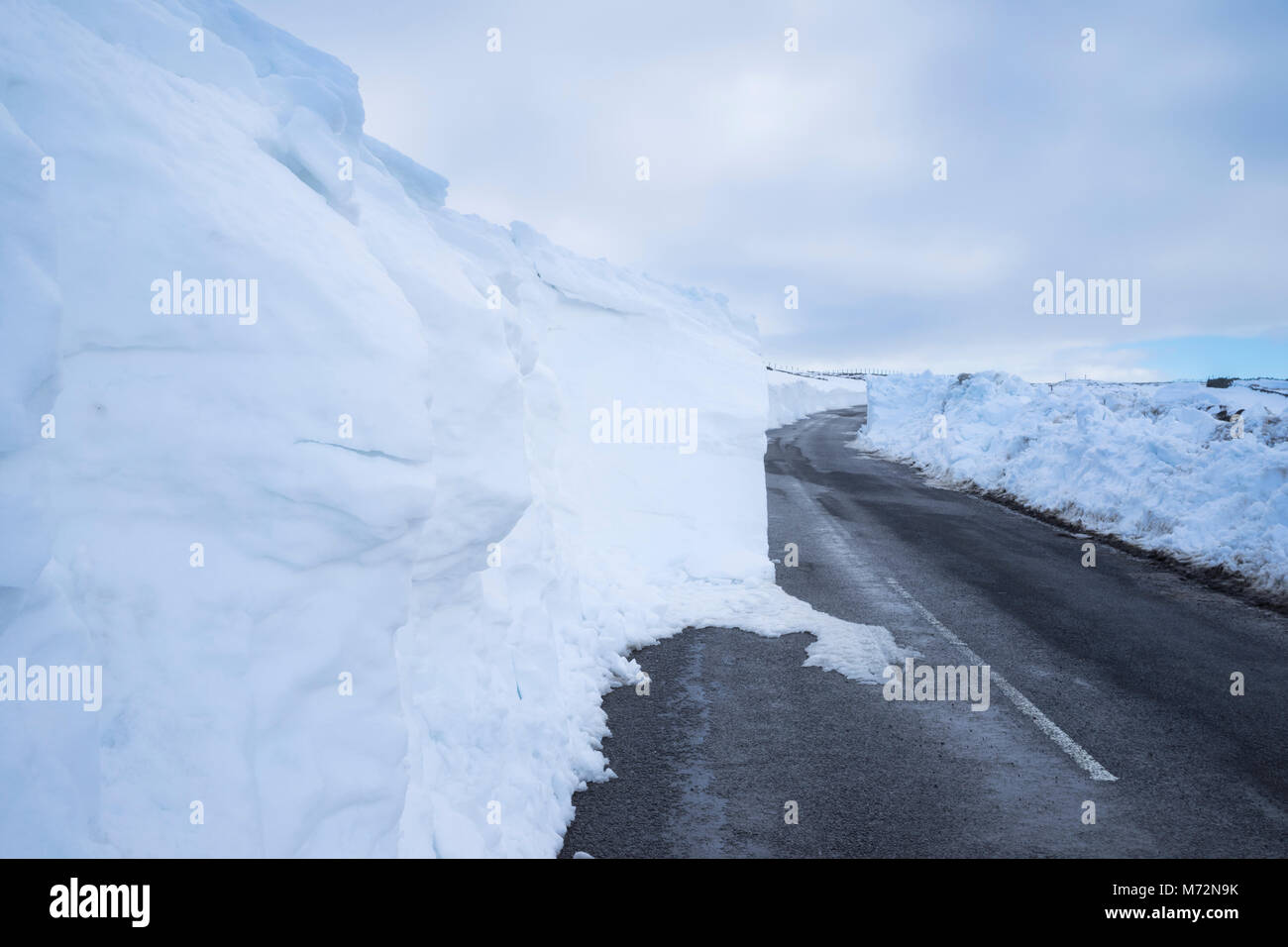 Landstraße nahe Allenheads in der North Pennines Gebiet von außergewöhnlicher natürlicher Schönheit, teilweise durch Schneeverwehungen gesperrt nach dem "Tier aus dem Osten Stockfoto