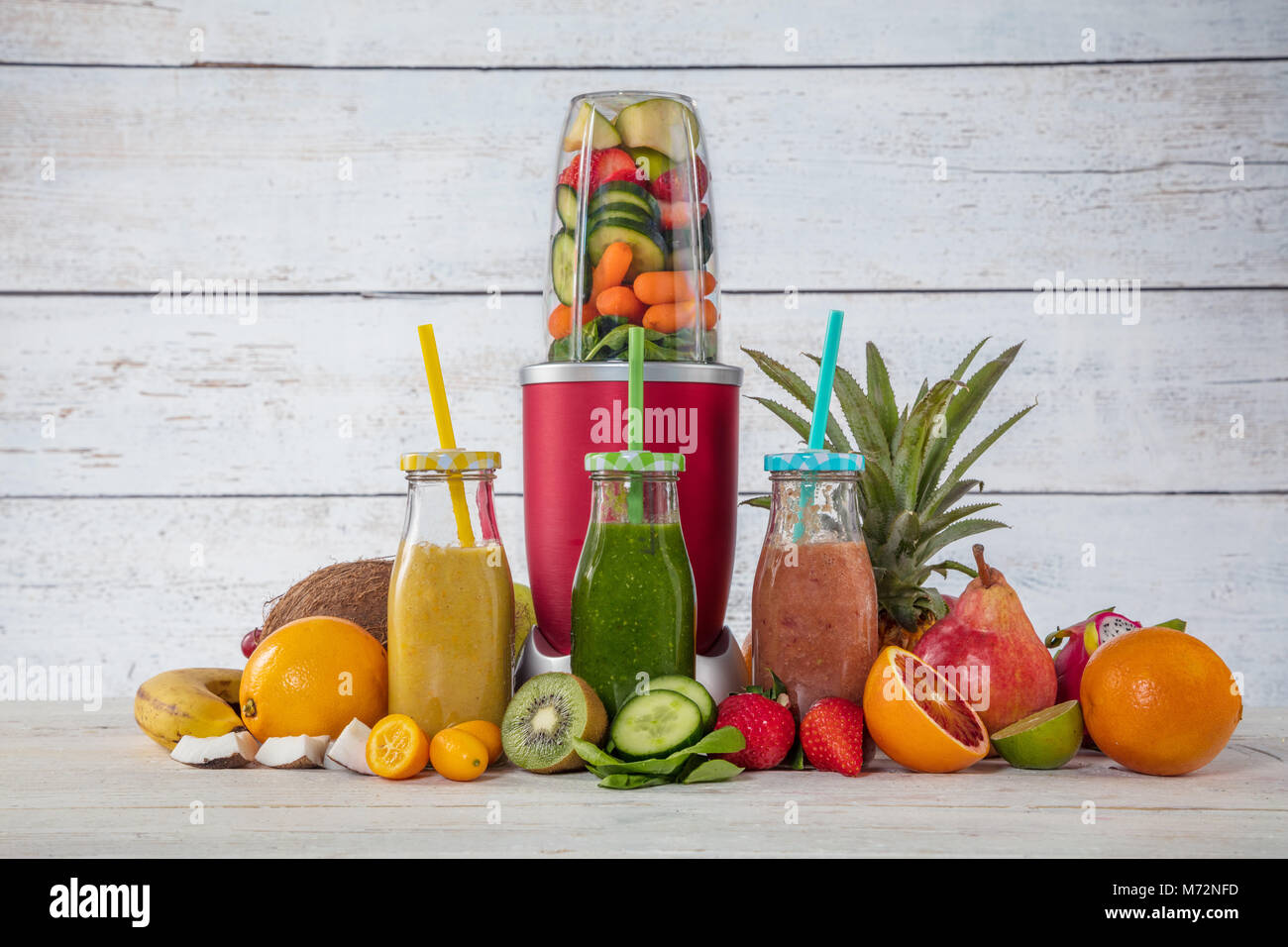Smoothie Maker Mixer mit Fruchtstücken Zutaten, im Interieur aus Holz gelegt. Gesundes Getränk und Lebensstil Stockfoto
