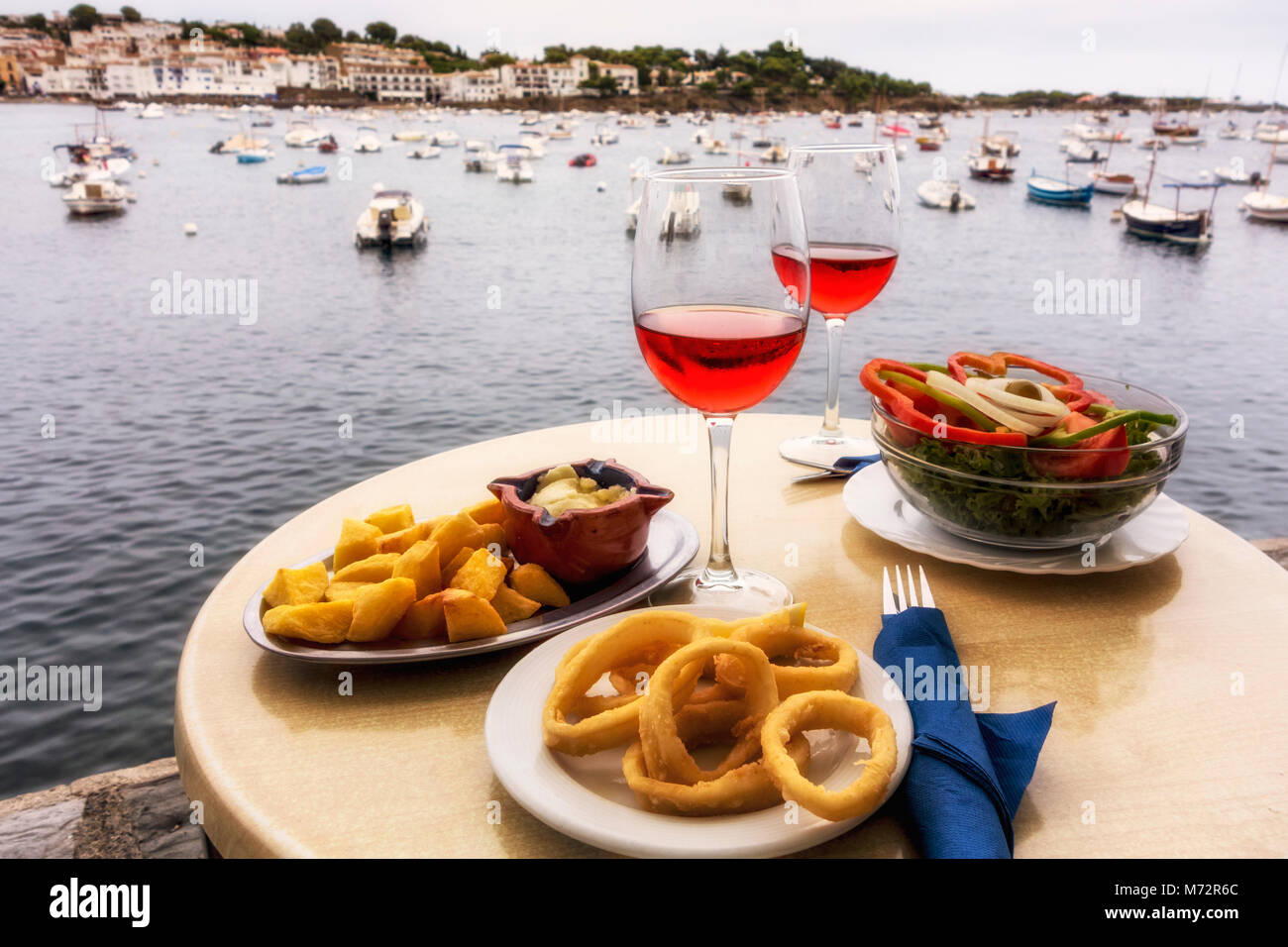 Zwei Gase von Rose und Tapas am Tisch, mit Hafen im Hintergrund, Cadaques, Alt Emporda Comarca, Costa Brava, Katalonien, Spanien Stockfoto