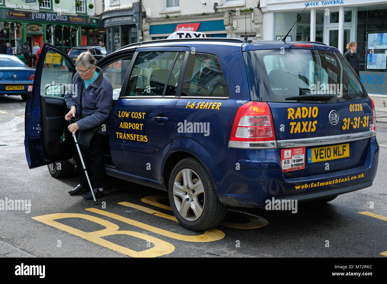 Eine Dame aus einem Mini cab oder Taxi in Cornwall. Stockfoto