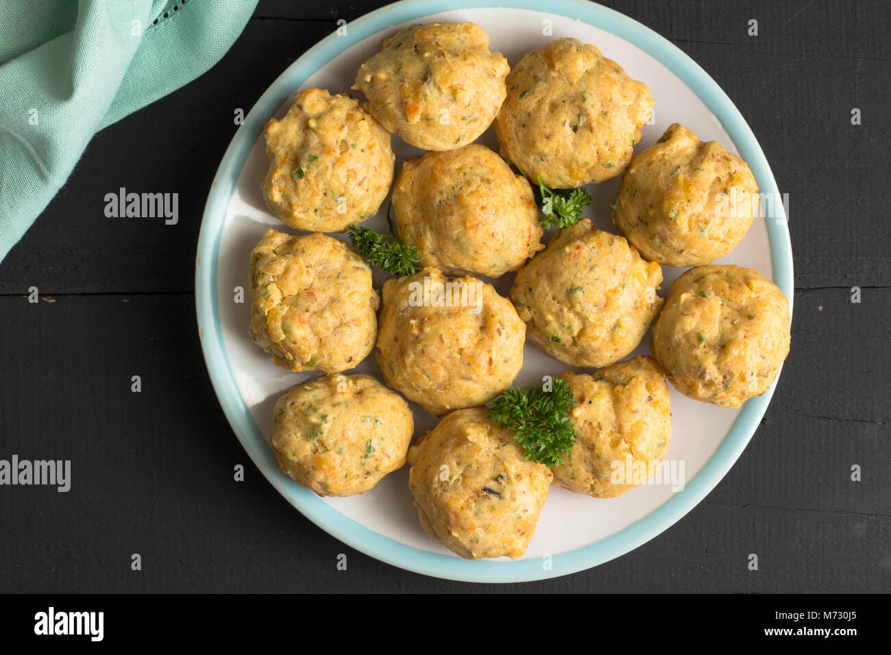 Herzhafte Muffins auf einem Teller. Ansicht von oben Hintergrund von Käse und Kraut Muffins auf rustikalen schwarz Tabelle isoliert Stockfoto