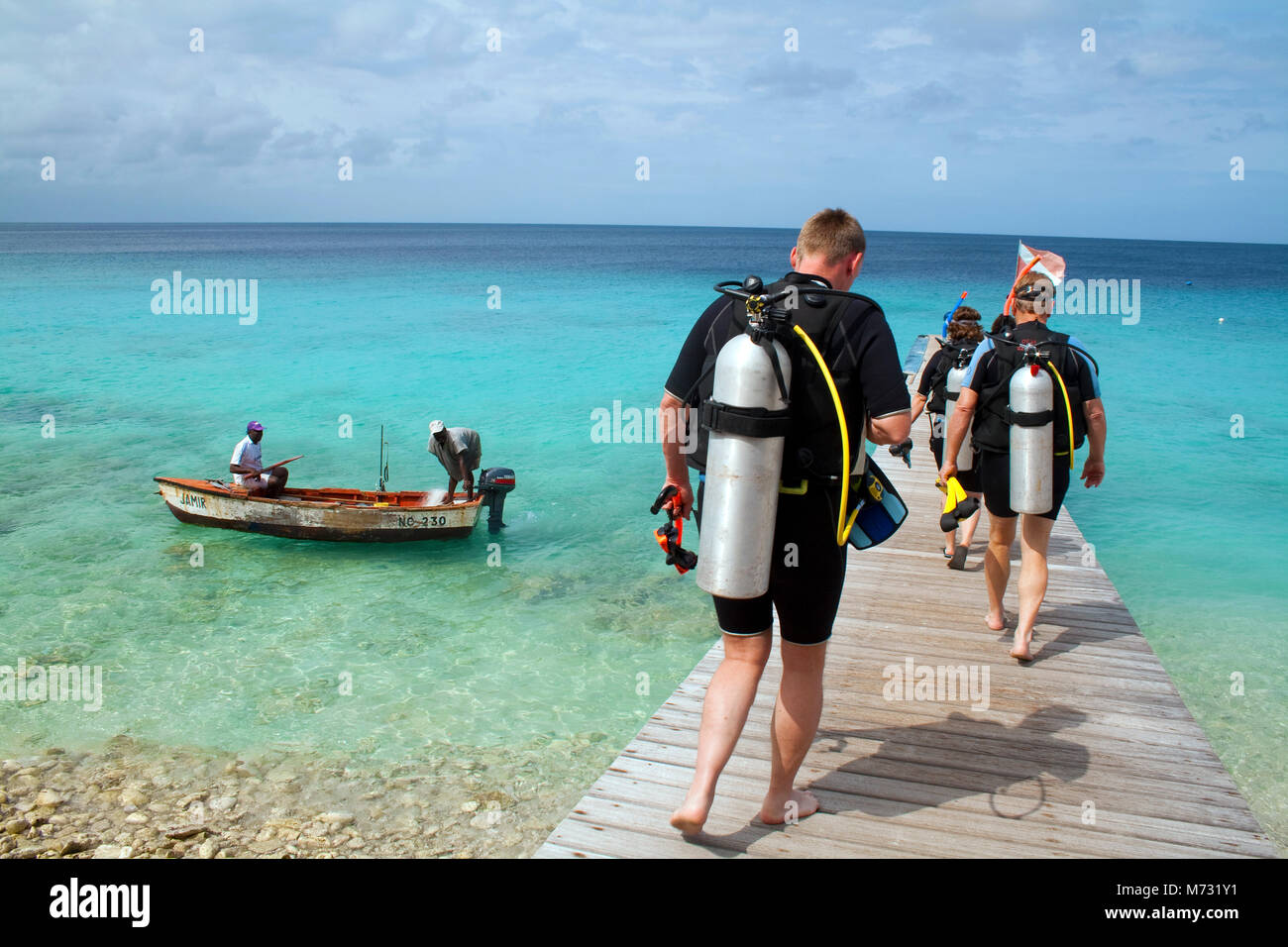 Scuba Diver zu Fuß am Steg am Strand Playa Kalki, Curacao, Niederländische Antillen, Karibik, Karibik Stockfoto