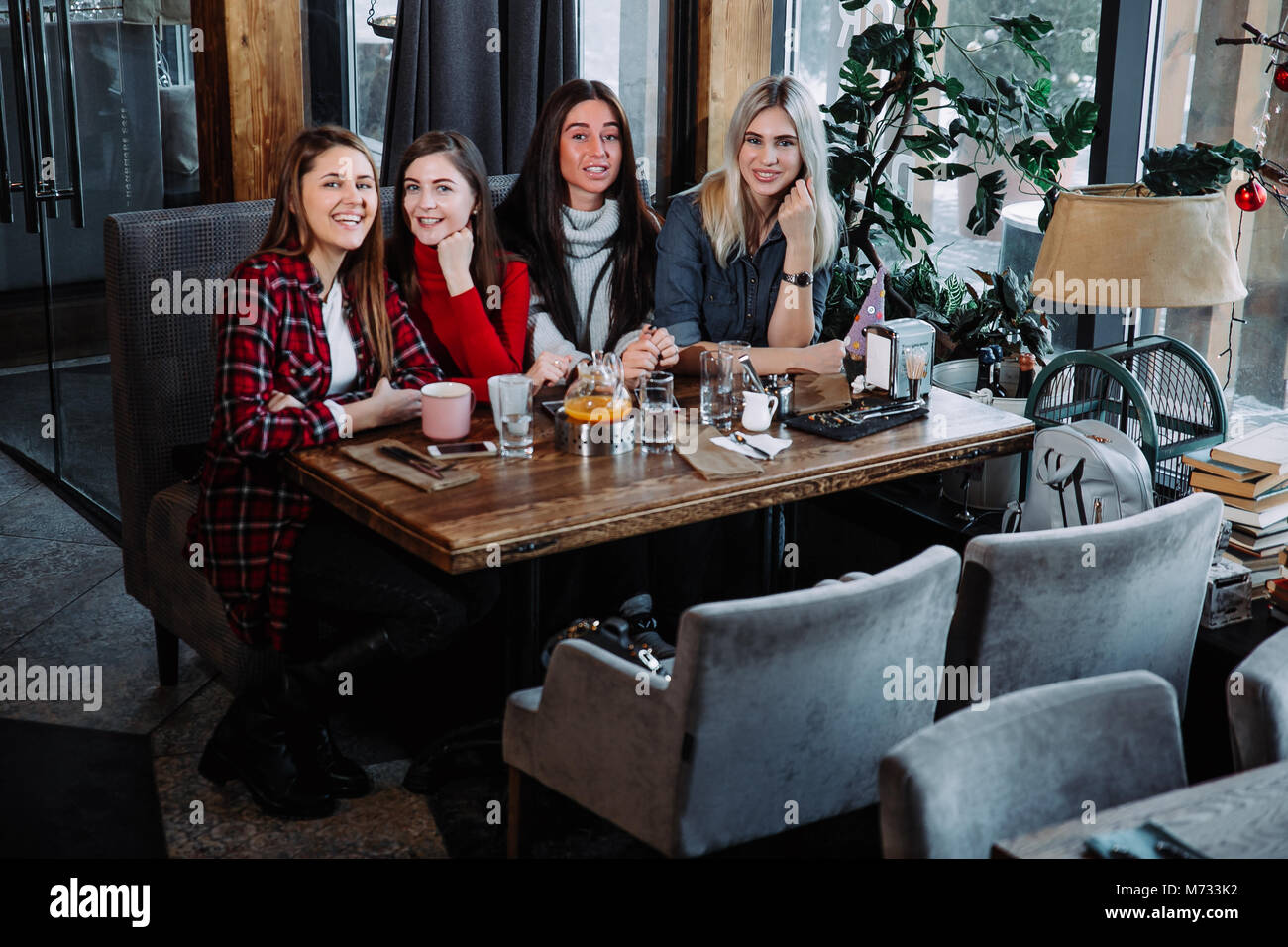 Vier Freunde im Cafe Blick in die Kamera und Lachen Stockfoto