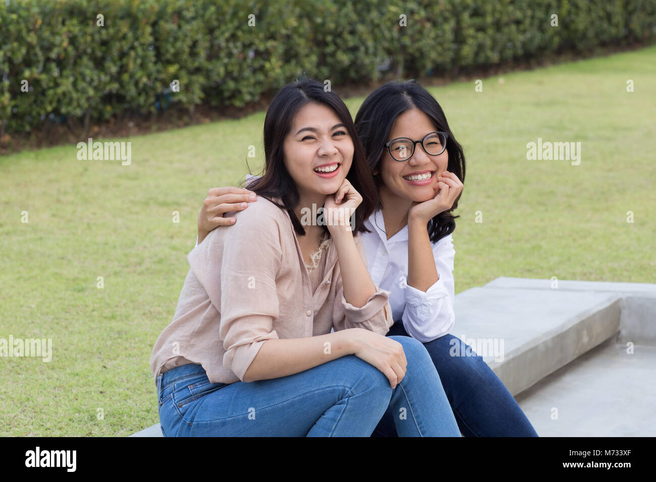 Junge asiatische Frauen Freundschaft Konzept mit lächelnden Frauen nebeneinander sitzen Stockfoto
