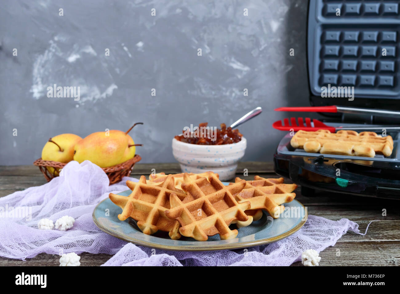 Knusprige golden vanilla Wafers mit pear Jam, elektrische Wafer Teller auf einem hölzernen Hintergrund. Stockfoto