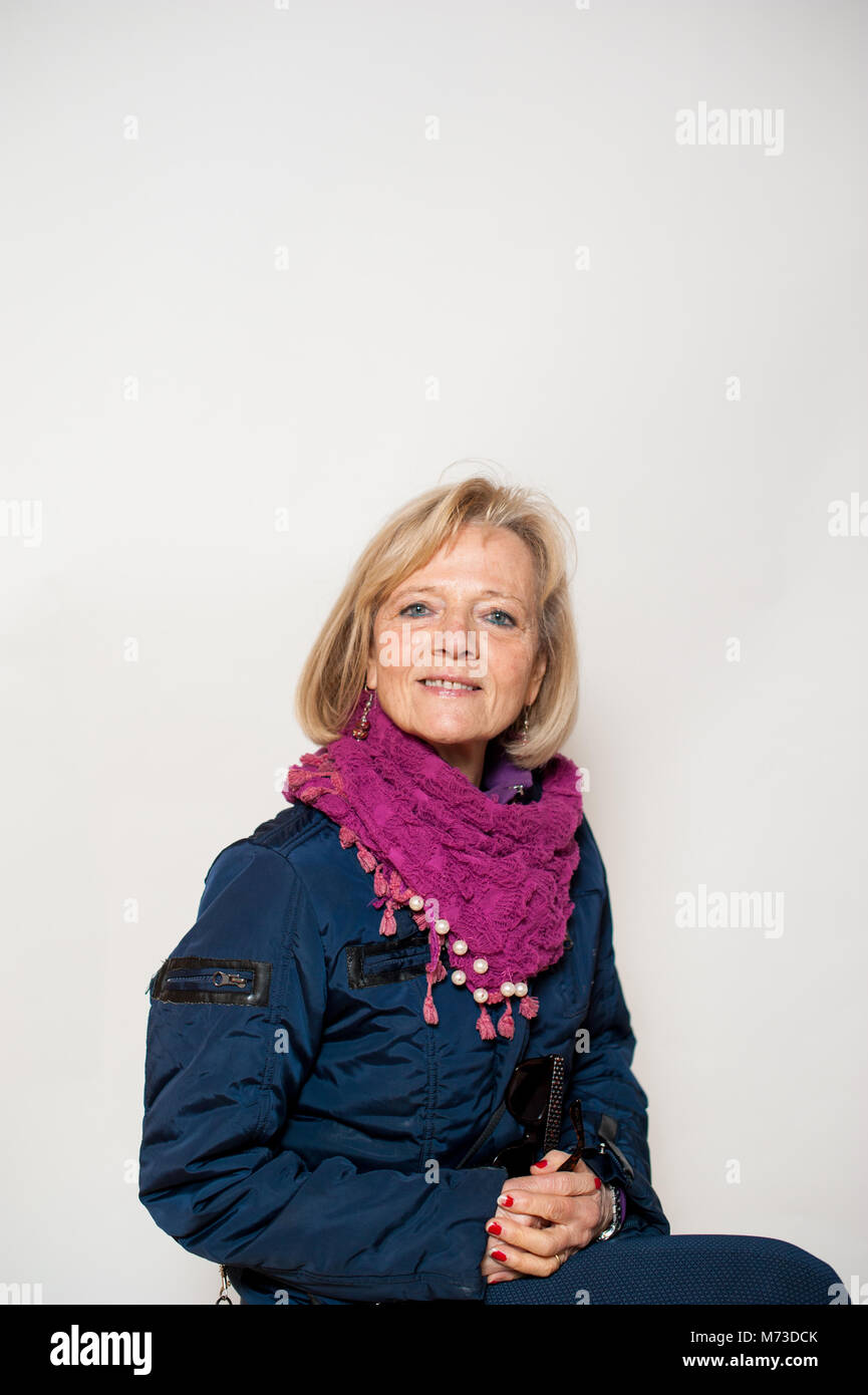 Porträt einer 65-jährigen Frau im Winter Kleidung, grauen Hintergrund, Studio shot Stockfoto