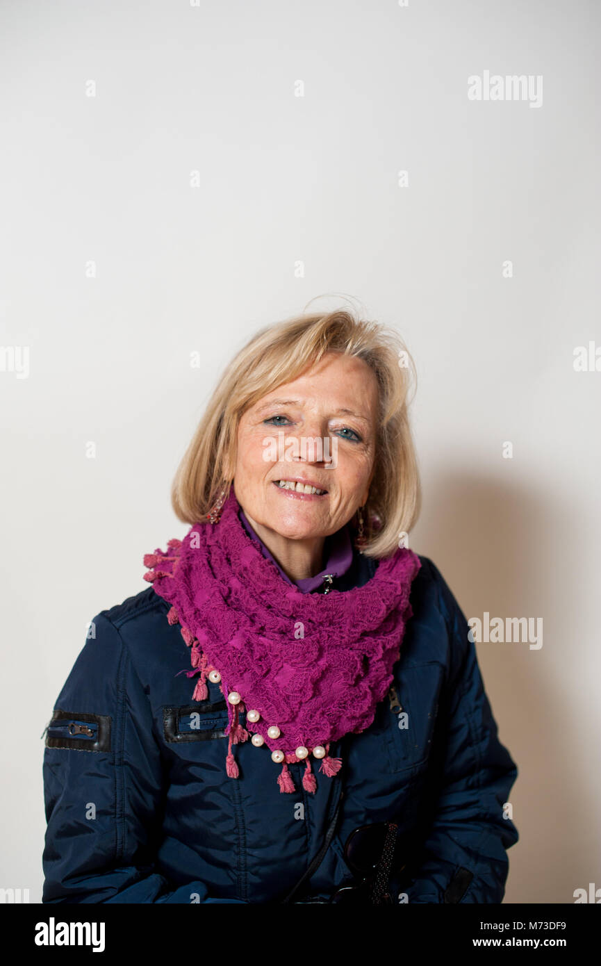 Porträt einer 65-jährigen Frau im Winter Kleidung, grauen Hintergrund, Studio shot Stockfoto