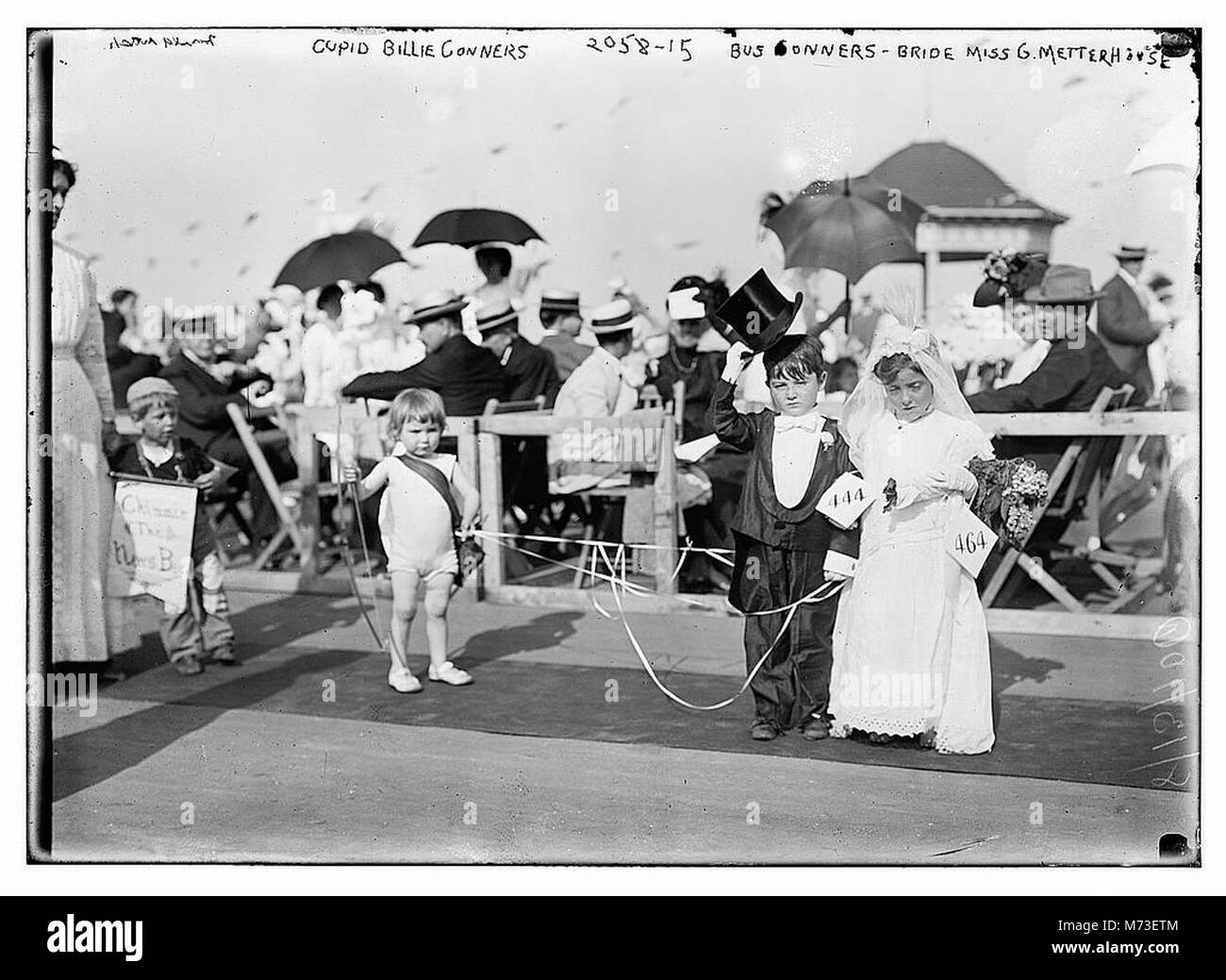 Ein Foto, das einen Moment mit Cupid Billie Conners, Bus Conners und der Braut Miss G. Metterhouse festnimmt, wahrscheinlich von einer Hochzeit oder einem gesellschaftlichen Ereignis, in dem die beteiligten Personen hervorgehoben werden. Stockfoto