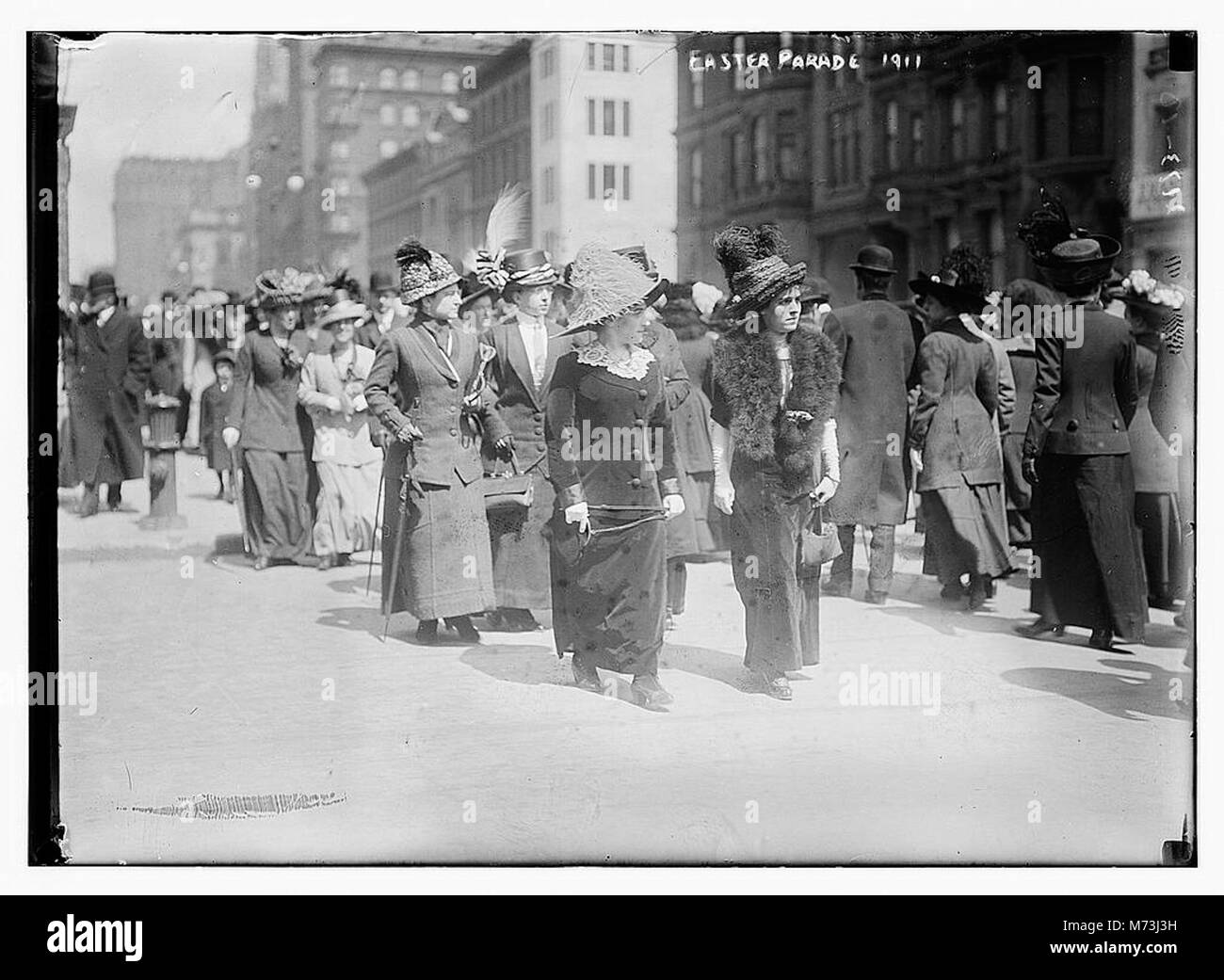 Eine Szene aus der Osterparade von 1911, die eine festliche Prozession auf den Straßen der Stadt mit elegant gekleideten Personen und raffinierten Hüten darstellt, die die Tradition der Osterparaden im Amerika des frühen 20. Jahrhunderts feiert. Stockfoto