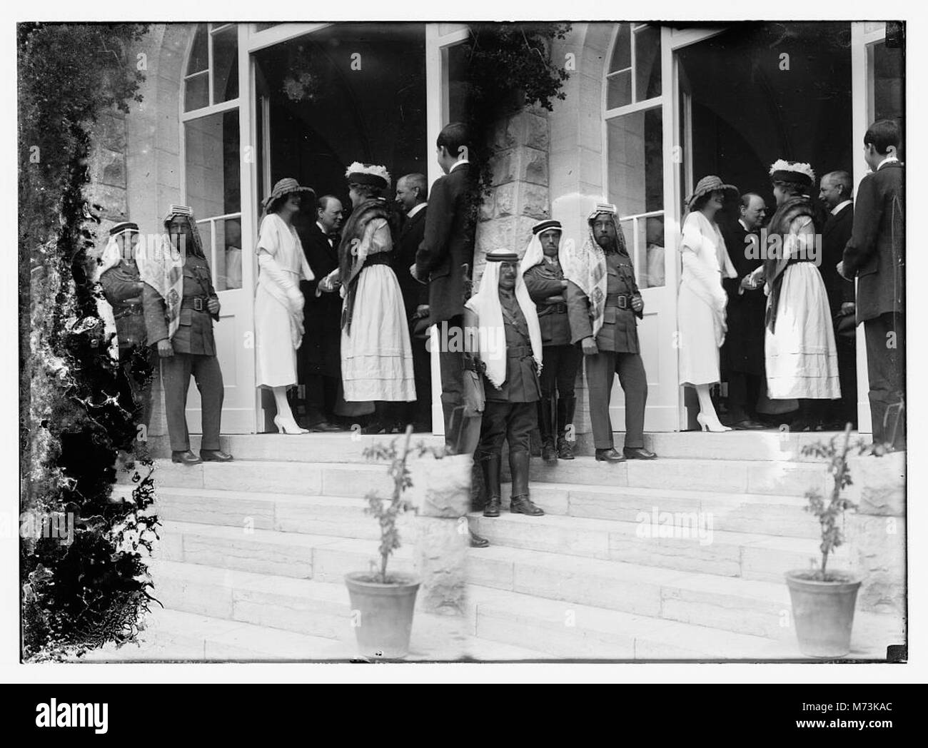 Foto von Emir Abdullah (dritter von links) und Herrn und Frau Winston Churchill, die Bertha und Frederick Vester bei einem Empfang im Regierungsgebäude in Jerusalem begrüßen. Das Bild fängt die historischen politischen Persönlichkeiten und den formalen Rahmen der Veranstaltung ein. Stockfoto