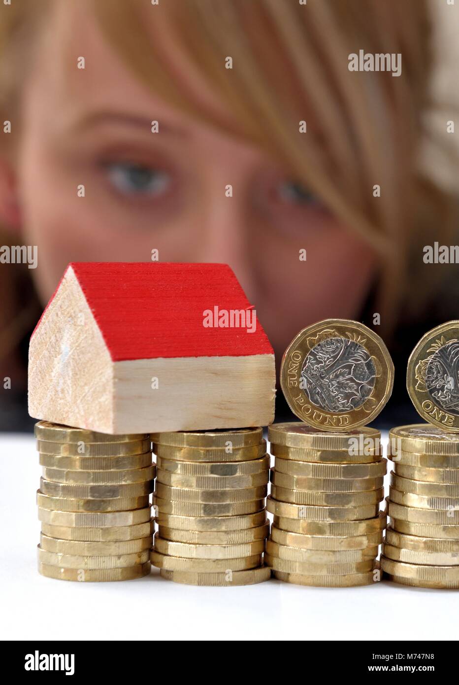 Ein kleines Haus auf einem Stapel von einem Pfund Münzen Haus Kauf Konzept Stockfoto