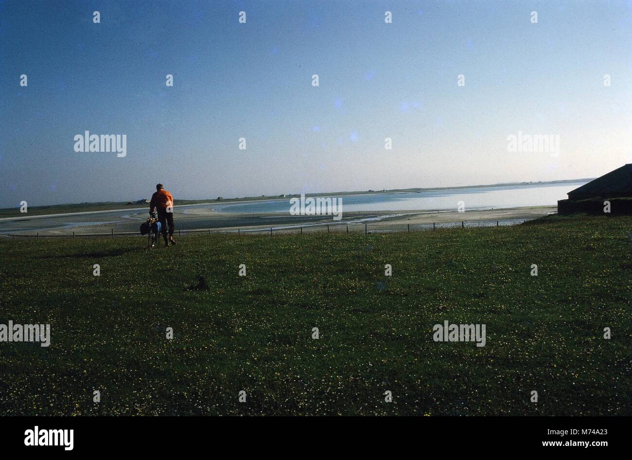 Ein Mann neben seinem Fahrrad über eine Wiese, die mit Blick auf die Küste, 1965. () Stockfoto