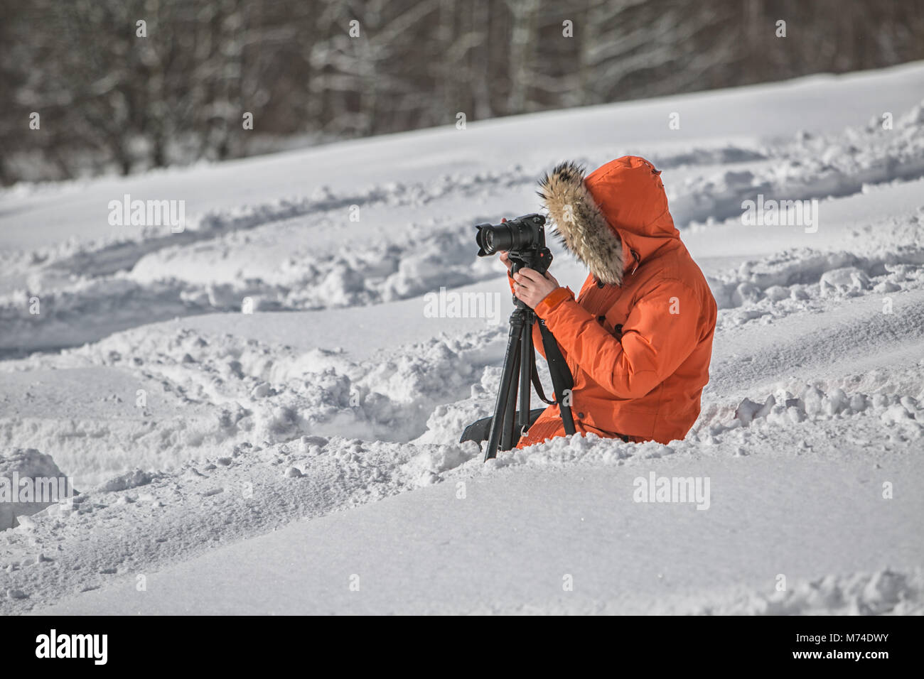 Videofilmer im Schnee Berge mit Stativ Sommertag in Geogria Stockfoto